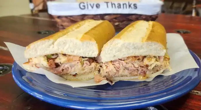 Bada Bing Supreme — French roll, hot ham, turkey, bacon bits, swiss cheese, grilled onion, green & red peppers, and mayo